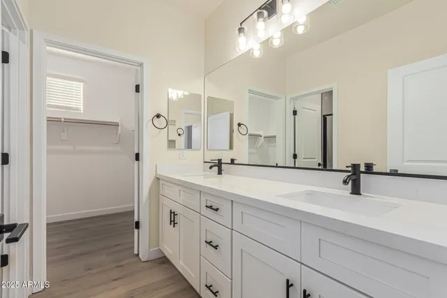 a bathroom with double vanity sink and a mirror