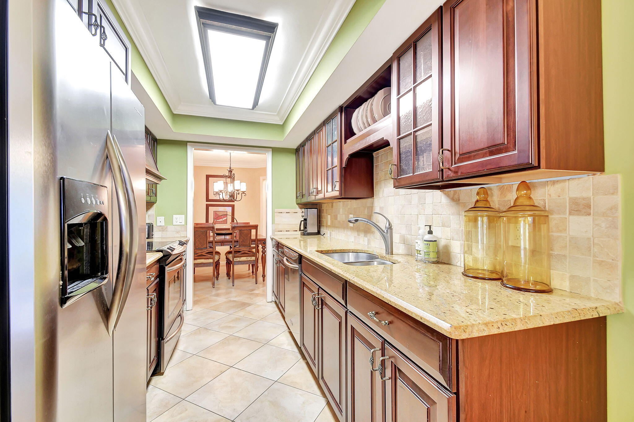318 Southeast 7th Avenue, Unit 3 Delray Beach, FL 33483 - Photo 16 of 44 a kitchen with stainless steel appliances granite countertop a refrigerator a sink dishwasher a stove and a dining table with wooden floor