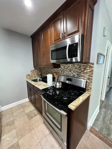 a stove top oven sitting inside of a kitchen