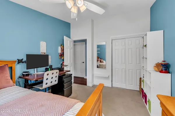 a bedroom with a bed and large windows