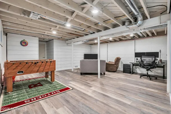 a view of a kitchen with kitchen island stainless steel appliances refrigerator stove and wooden floor