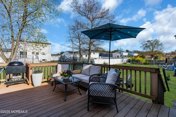 a patio table and chairs with the garden and wooden fence