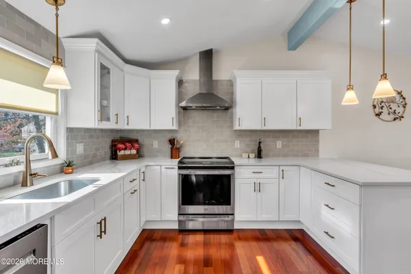 a kitchen with stainless steel appliances a white stove top oven sink and cabinets