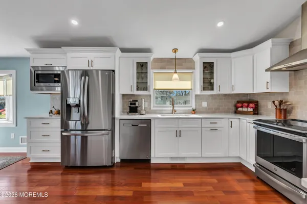 a kitchen with granite countertop a refrigerator stove and sink