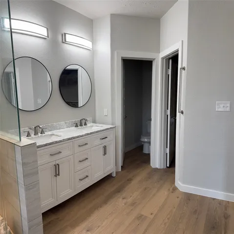 a bathroom with a granite countertop sink a toilet and shower