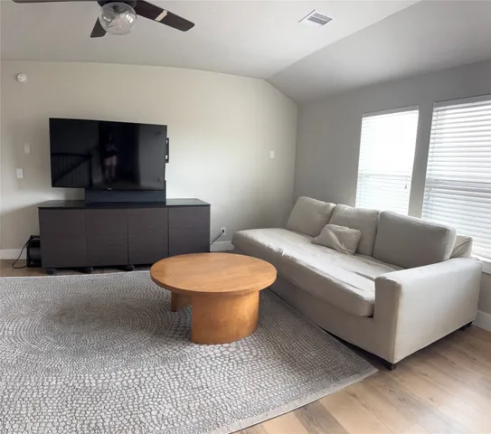 a living room with furniture a window and a chandelier