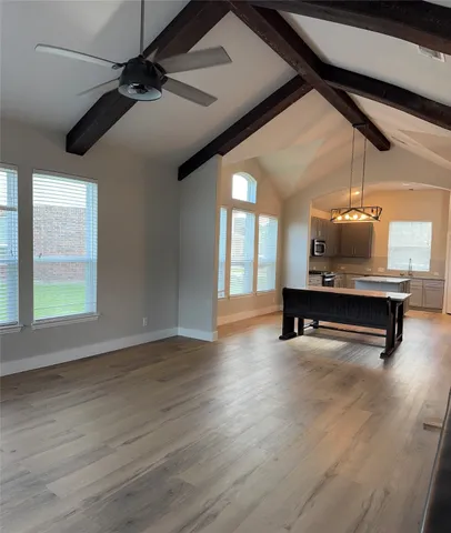 a room with gym equipment and wooden floor