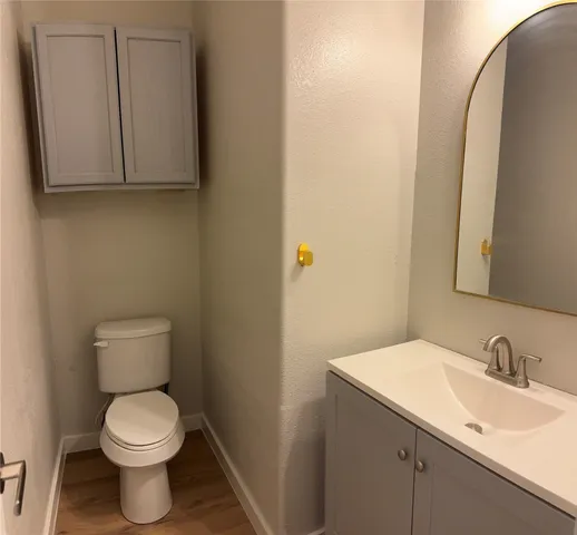 a view of an empty room with wooden floor and a ceiling fan
