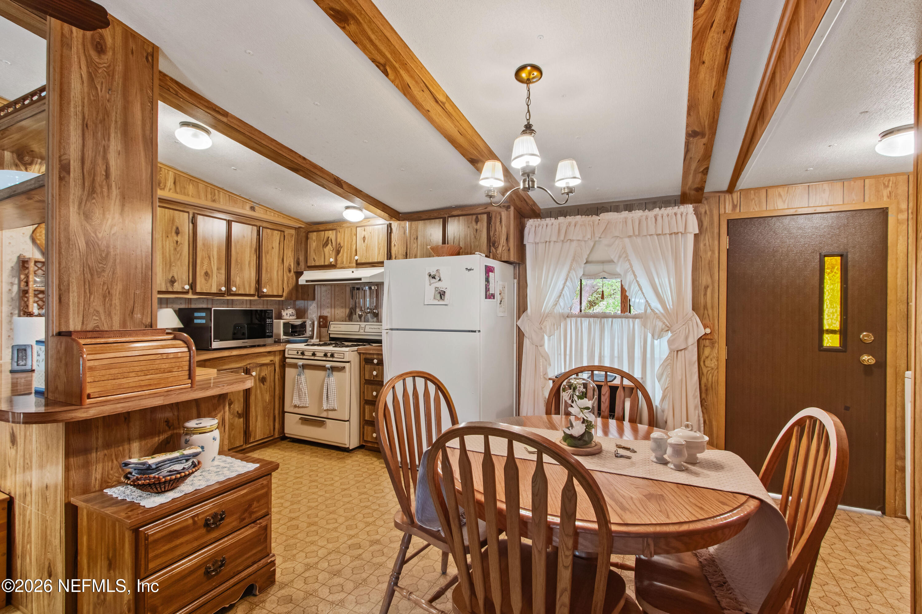 206 Anthony Avenue Interlachen, FL 32148 - Photo 22 of 32 a kitchen with stainless steel appliances granite countertop a stove a refrigerator a dining table and chairs with wooden floor