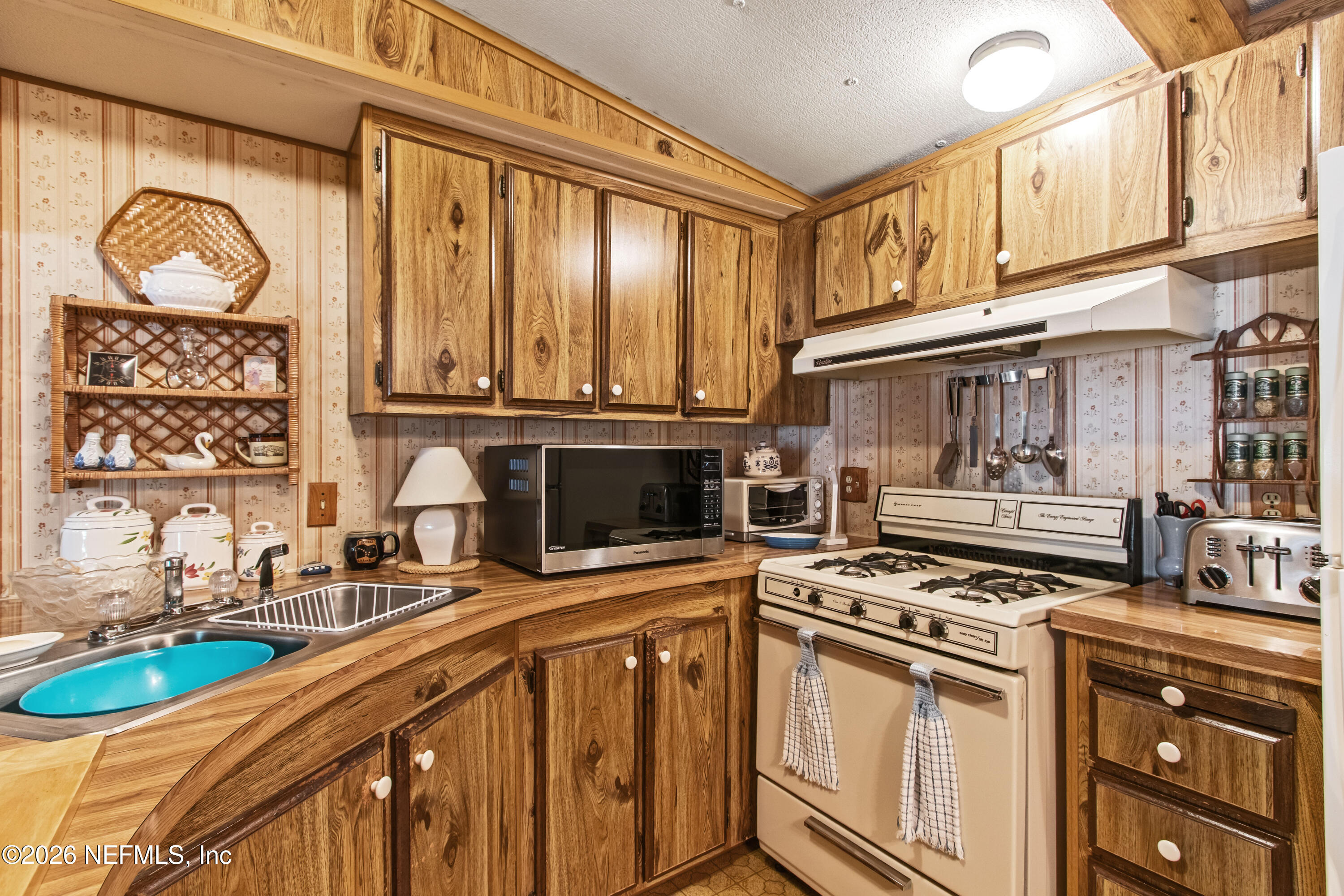206 Anthony Avenue Interlachen, FL 32148 - Photo 25 of 32 a kitchen with a stove a sink and a microwave