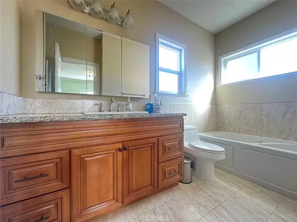 a bathroom with a granite countertop toilet a sink and a bathtub
