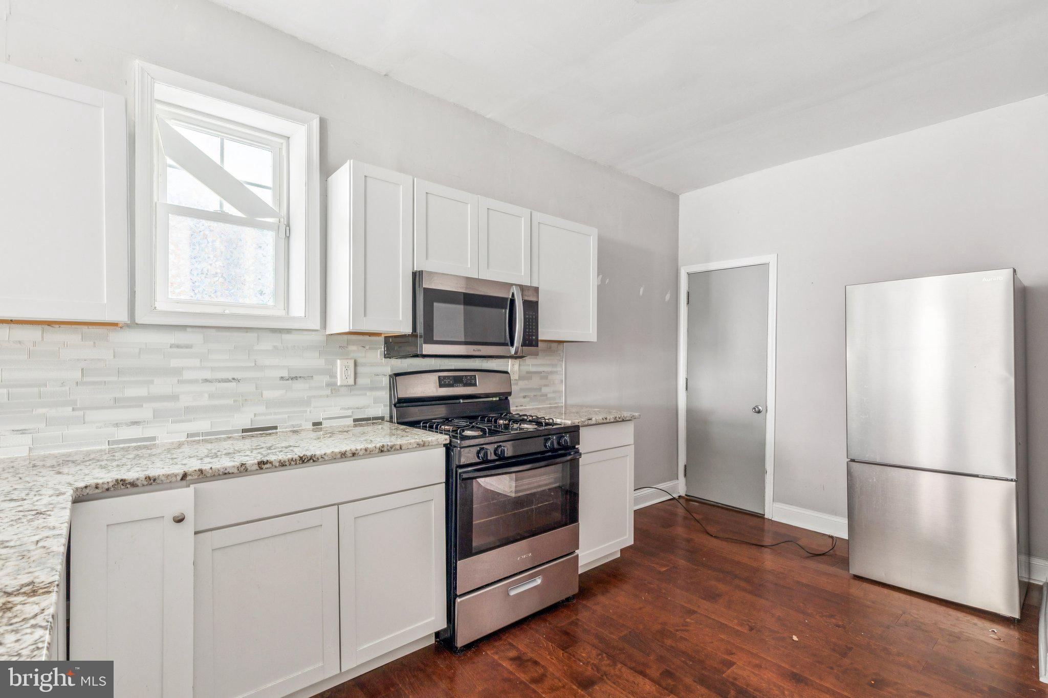 1632 North Dover Street Philadelphia, PA 19121 - Photo 2 of 23 a kitchen with white cabinets stainless steel appliances and wooden floor