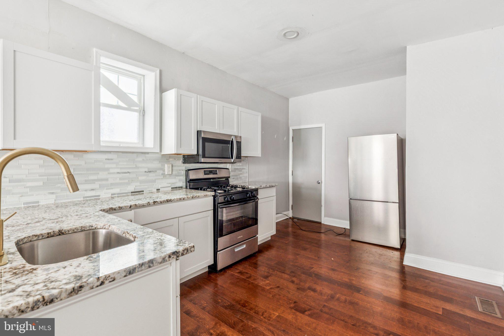 1632 North Dover Street Philadelphia, PA 19121 - Photo 3 of 23 a kitchen with a sink wooden floor and stainless steel appliances