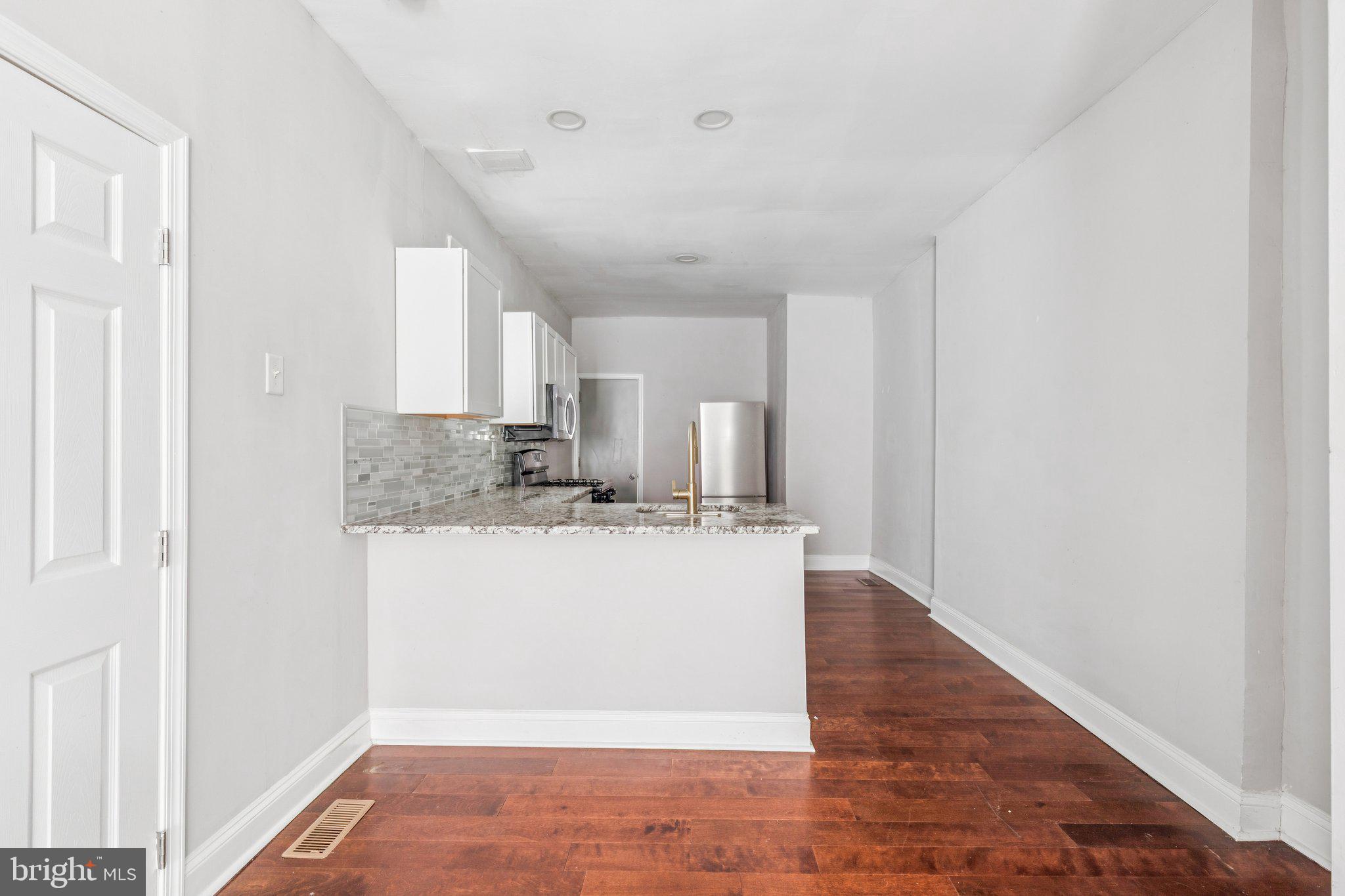1632 North Dover Street Philadelphia, PA 19121 - Photo 4 of 23 a room with kitchen island a sink wooden floor and view living room