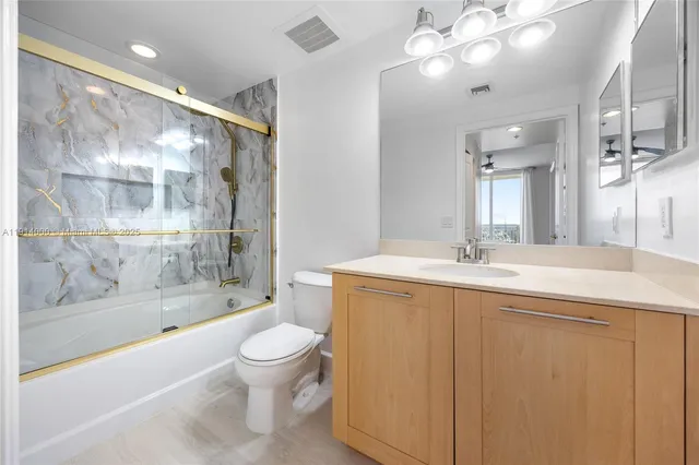 a bathroom with a bathtub shower sink vanity and toilet