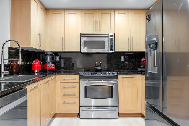 a kitchen with stainless steel appliances granite countertop a stove a sink and a microwave