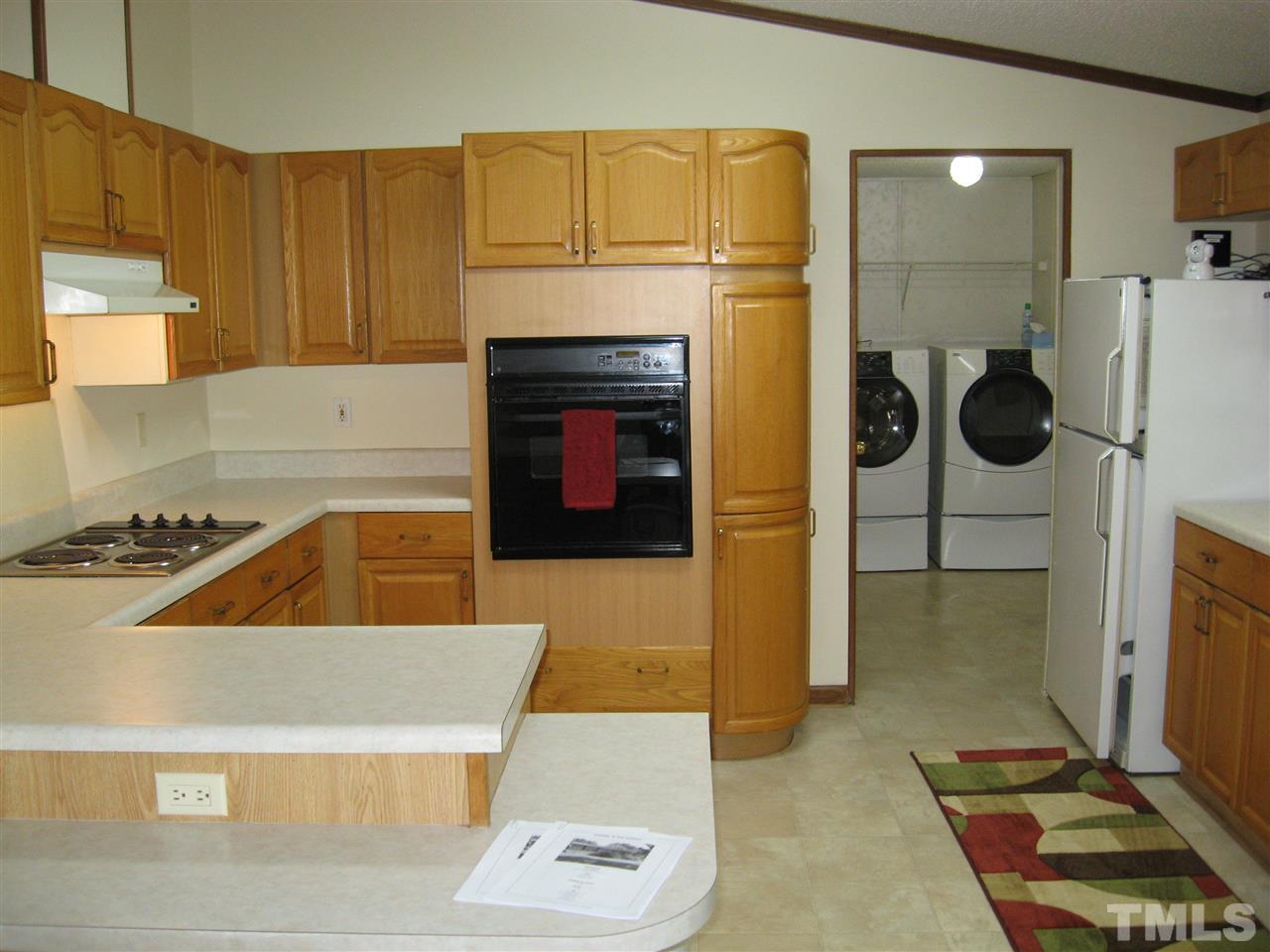 1445 L L Cooper Road Cameron, NC 28326 - Photo 6 of 25 a kitchen with a refrigerator and a stove top oven