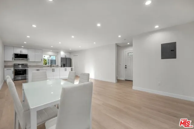 a living room with stainless steel appliances kitchen island granite countertop furniture wooden floor and a view of kitchen