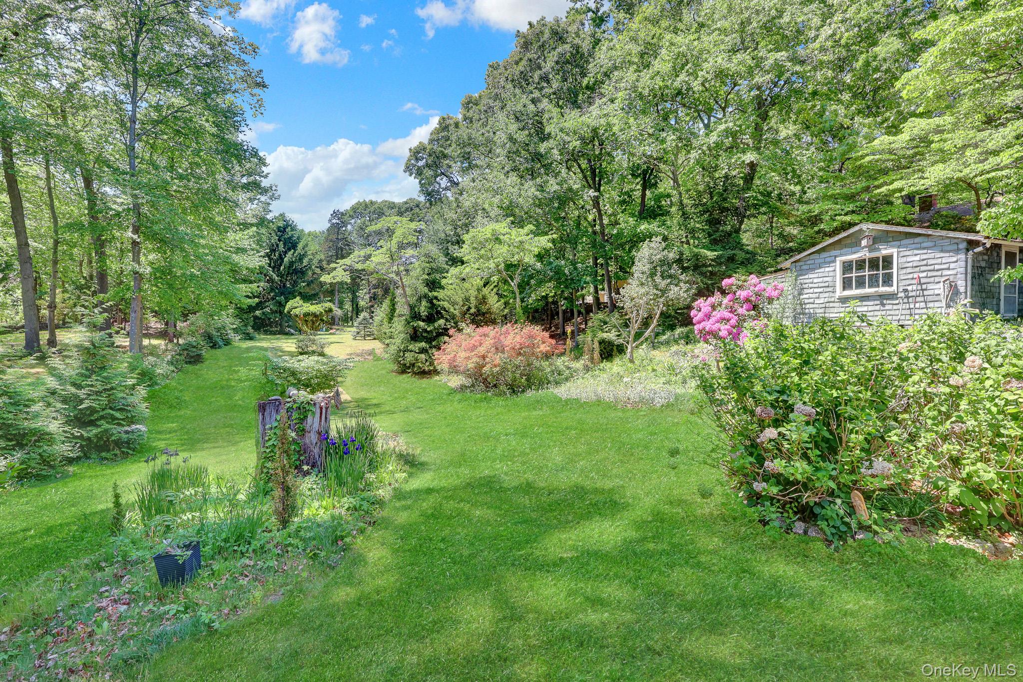 100 Elwood Road Northport, NY 11768 - Photo 26 of 39 Expansive green lawn with mature trees and diverse landscaping