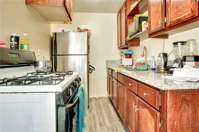 a kitchen with stainless steel appliances granite countertop a stove a refrigerator and a sink