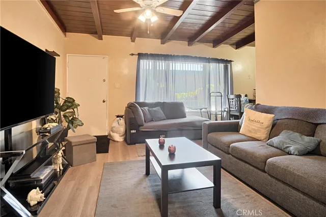 a living room with furniture a flat screen tv and a window