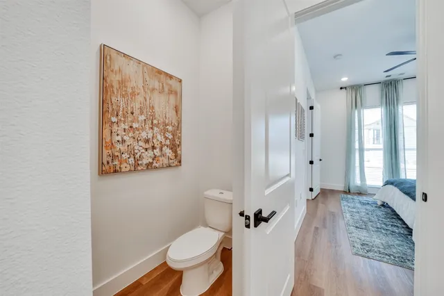 a bathroom with a granite countertop toilet a sink and a large mirror