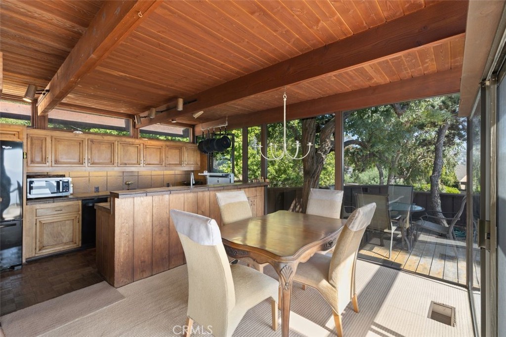 394 Pinecrest Drive Laguna Beach, CA 92651 - Photo 15 of 41 a view of a patio with table and chairs under an umbrella with a small yard