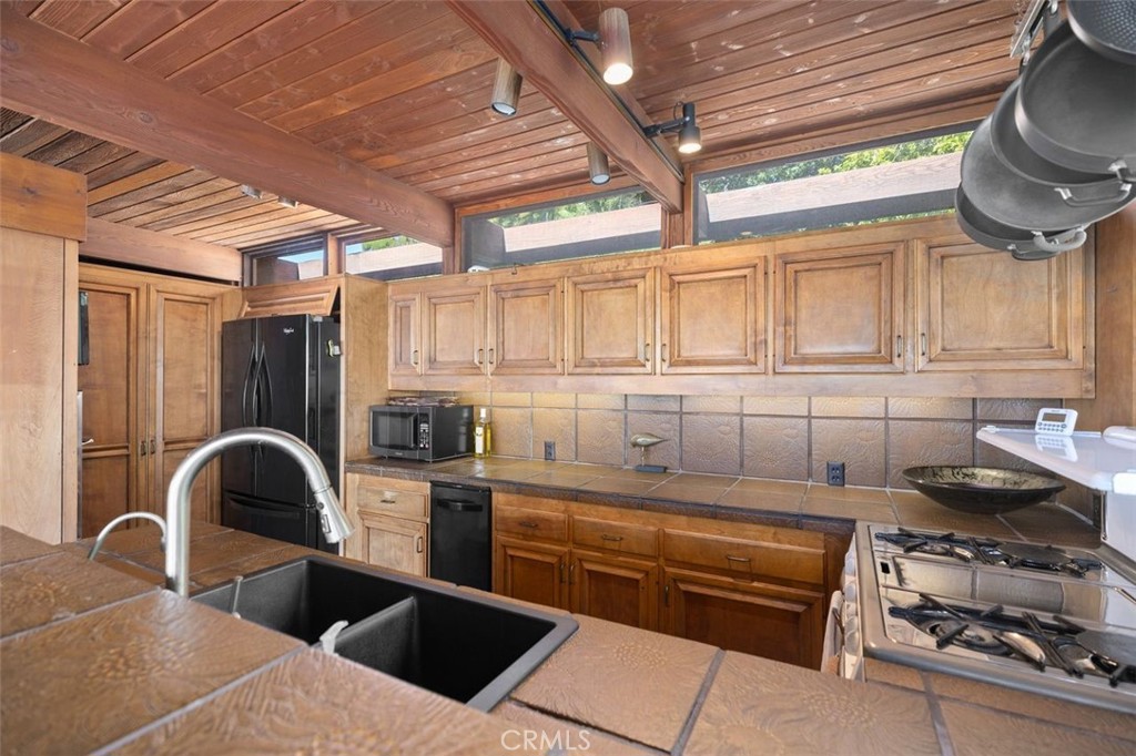 394 Pinecrest Drive Laguna Beach, CA 92651 - Photo 20 of 41 a kitchen with stainless steel appliances granite countertop a stove a sink and a refrigerator