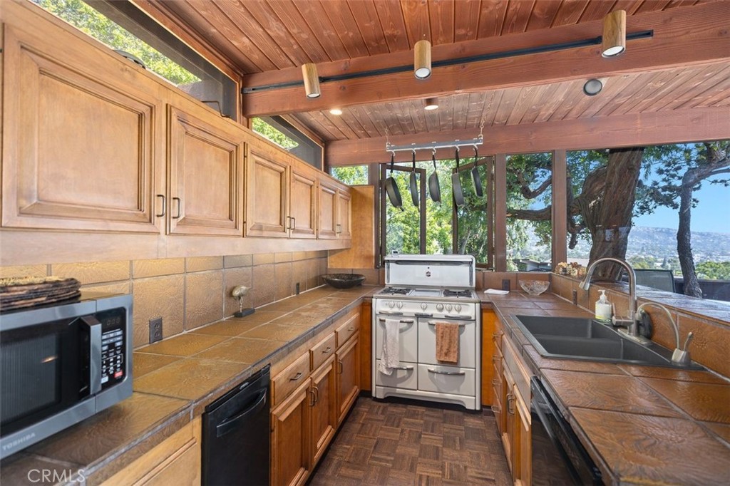 394 Pinecrest Drive Laguna Beach, CA 92651 - Photo 21 of 41 a kitchen with stainless steel appliances granite countertop a sink a stove and a wooden cabinets