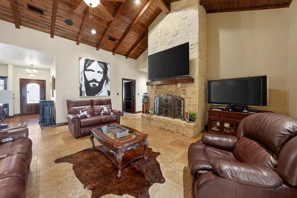 a living room with furniture a flat screen tv and a fireplace