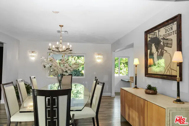 a view of a dining room with furniture a chandelier and wooden floor