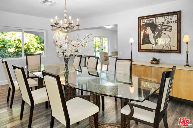 a view of a dining room with furniture a chandelier and wooden floor