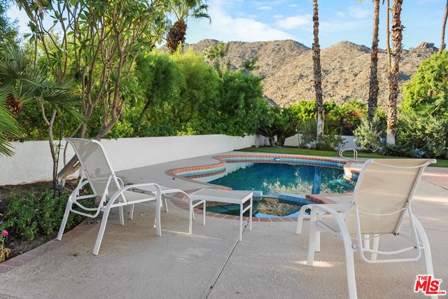 a view of a backyard with a patio table and chairs