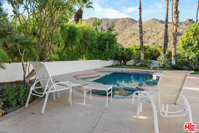 a view of a backyard with a patio table and chairs