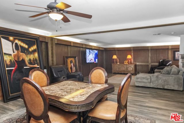 a dining room with furniture a rug a chandelier and wooden floor