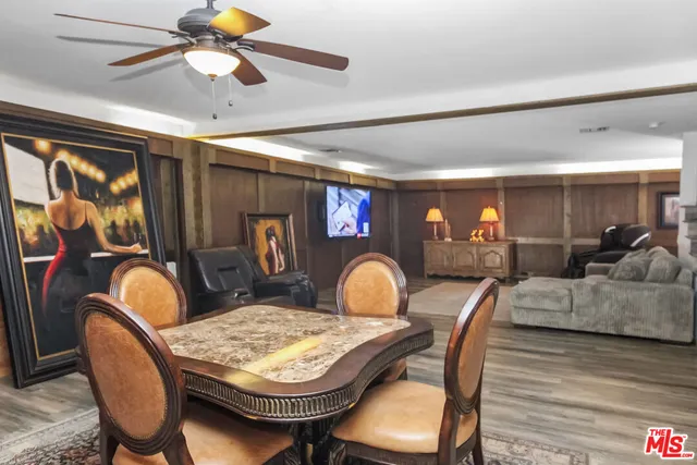 a dining room with furniture a rug a chandelier and wooden floor