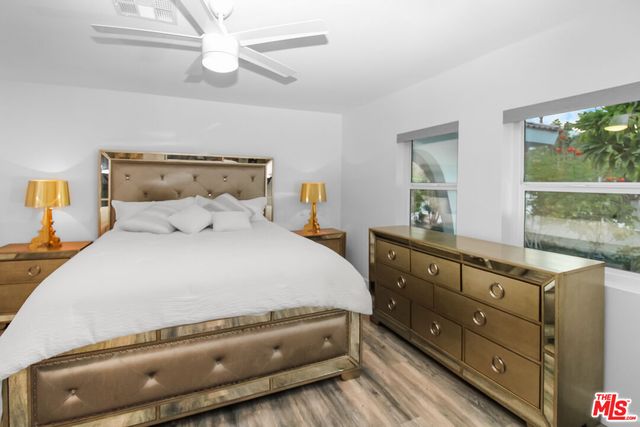 a white bed sitting in a room next to a window