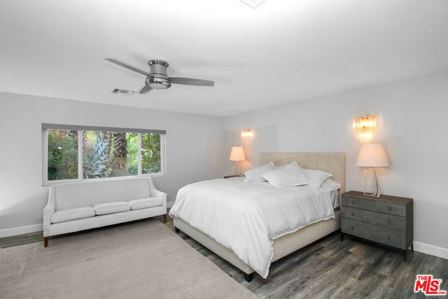 a bathroom with a granite countertop sink a mirror and a toilet
