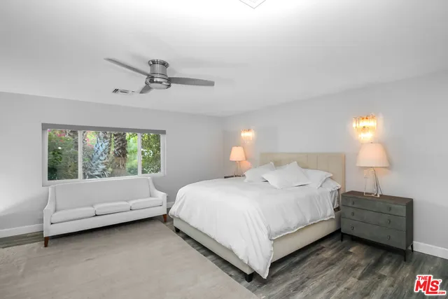 a bathroom with a granite countertop sink a mirror and a toilet