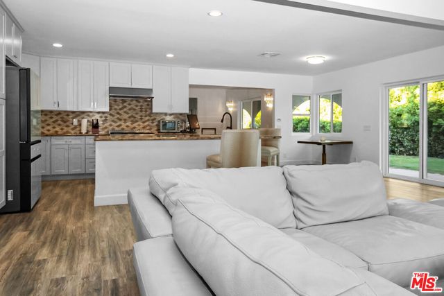 a large white kitchen with kitchen island a sink table and chairs