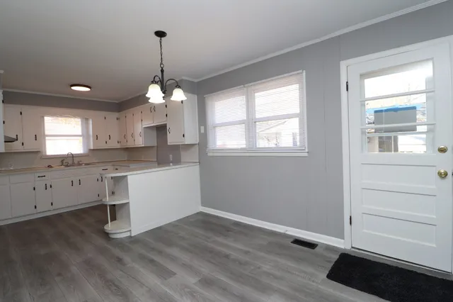 a view of an empty room with wooden floor