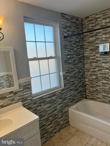 a bathroom with a bathtub and a window