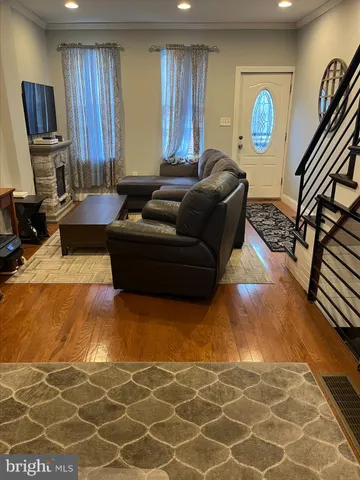 a living room with furniture a flat screen tv and a window