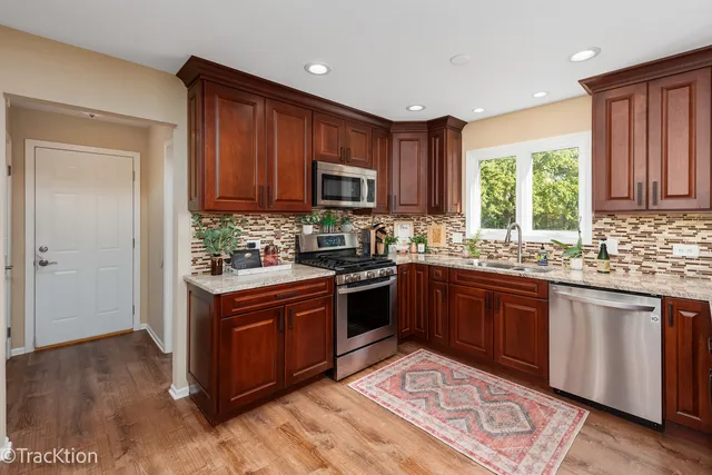 a kitchen with stainless steel appliances granite countertop a stove a sink dishwasher and a refrigerator
