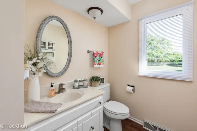 a bathroom with a granite countertop toilet a sink and a mirror