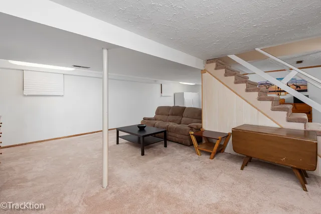a living room with furniture and a air conditioner vent