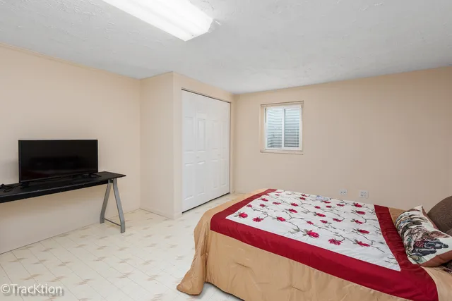 a bedroom with a bed and a lamp on dresser