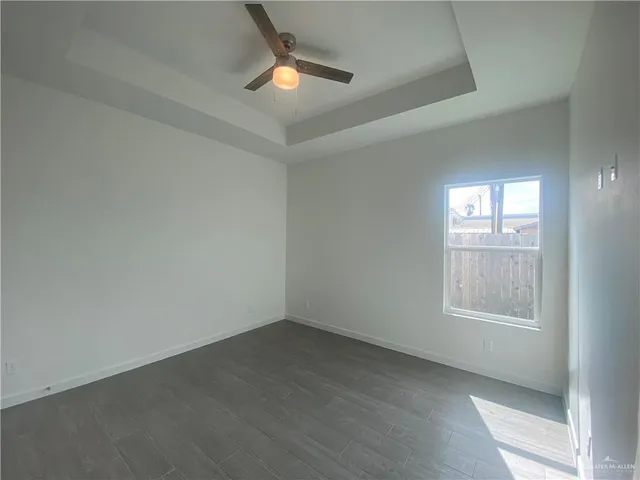 an empty room with a window and ceiling fan