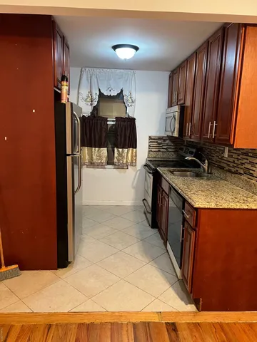 a kitchen with granite countertop stainless steel appliances a stove a sink and a microwave