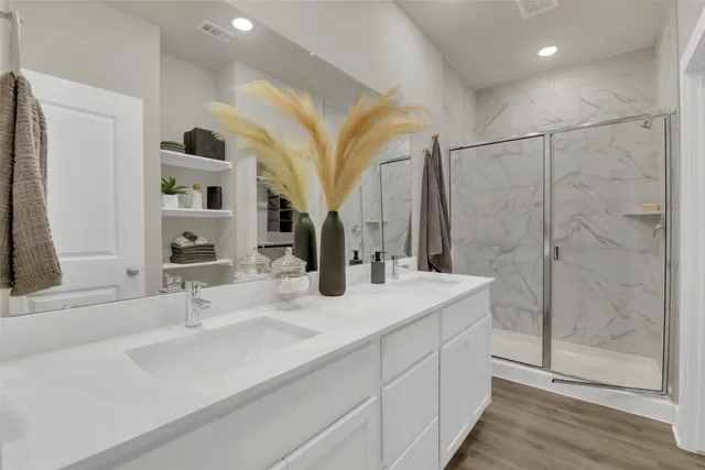 a bathroom with a double vanity sink mirror and shower